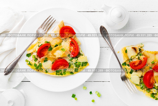 Omelet. Eggs fried. Scrambled eggs with green onion and fresh tomato. Omlette on white plate. Breakfast. Top view. White wooden background. Стоковое фото, агентство Ingram Publishing / Фотобанк Лори
