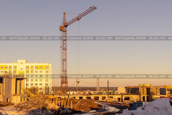 On a spring evening, a tower crane builds buildings on the outskirts of the city. Стоковое фото, фотограф Дмитрий Коростылев / Фотобанк Лори