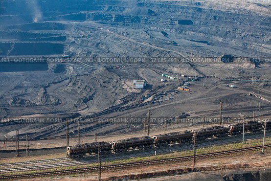Open pit extraction of coal in quarry "Bogatyr", Ekibastuz, Kazakhstan. Quarry machine and cargo train on railroad. Стоковое фото, фотограф Alexey Rezvykh / Фотобанк Лори