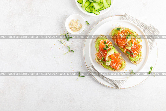Open sandwiches with salted salmon, guacamole avocado and microgreens. Seafood. Healthy food. Top view. Стоковое фото, агентство Ingram Publishing / Фотобанк Лори