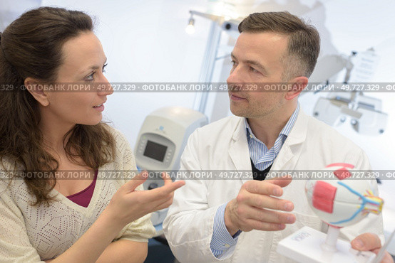 ophthalmologist using model eyeball to explain to patient. Стоковое фото, агентство Ingram Publishing / Фотобанк Лори