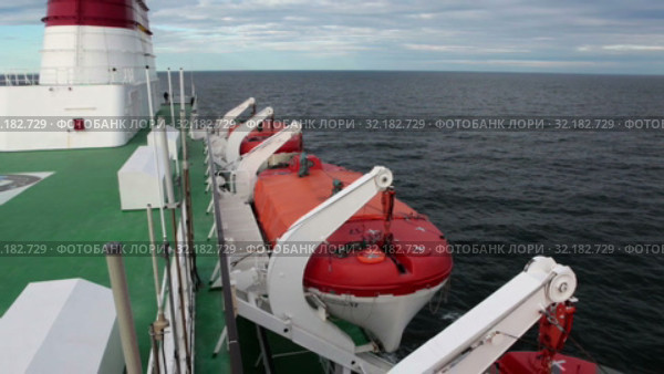 Оранжевые спасательные шлюпки висят по бокам судна. Круизный лайнер Viking Line в Балтийском море (2019 год). Редакционное видео, видеограф Кекяляйнен Андрей / Фотобанк Лори