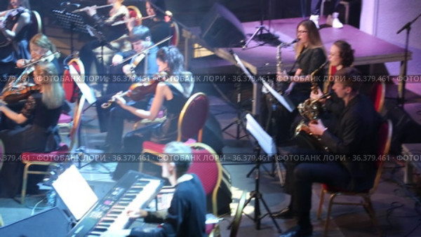 Orchestra Concert "Other Band". Concert of the symphony orchestra under bright scenic spotlights. Редакционное видео, видеограф Евгений Ткачёв / Фотобанк Лори