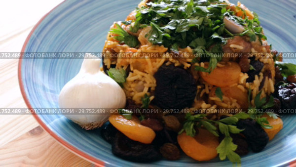 Oriental cuisine - pilaf with lamb, dried plums and apricots, saffron and sweet garlic. Стоковое видео, видеограф Яков Филимонов / Фотобанк Лори
