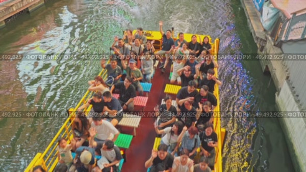 Osaka, Japan - Sep 21 2024, 4k, Panoramic view of Dotonbori river with a ship with tourists, a lot of people on embankment, there are a lot of advertising and illuminations on buildings, Osaka, Japan. Редакционное видео, видеограф Сергей Богомяко / Фотобанк Лори