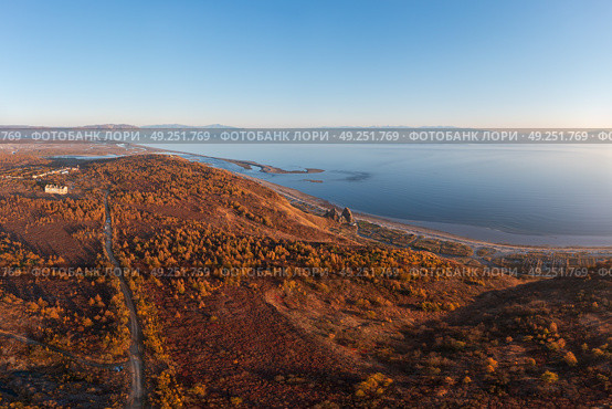 Осенний пейзаж. Панорамный аэрофотоснимок морского побережья. Вид сверху на грунтовую дорогу среди лиственниц. Вдалеке море и устье реки. Побережье Охотского моря. Магаданская область, Дальний Восток России. Стоковое фото, фотограф Андрей Степанов / Фотобанк Лори