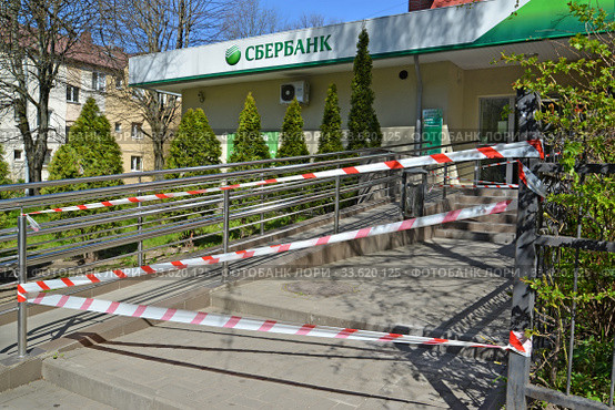Отделение Сбербанка огорожено сигнальной лентой во время эпидемии коронавируса COVID-19 в России. Калининград, улица Чекистов, дом 36 (2020 год). Редакционное фото, фотограф Ирина Борсученко / Фотобанк Лори