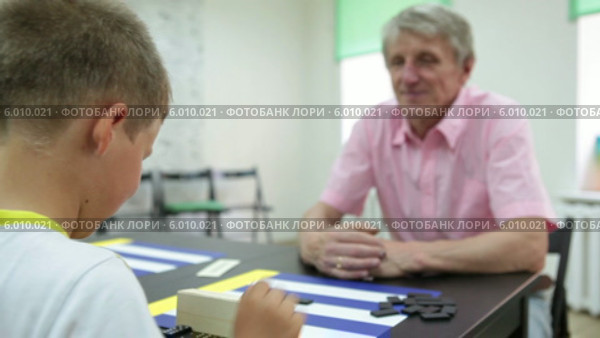 Отец с сыном играют в домино за столом. Стоковое видео, видеограф Кекяляйнен Андрей / Фотобанк Лори