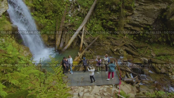 Outdoor activities. Tourists take pictures of the beautiful waterfall in Sochi National Park. Активный отдых на природе. Туристы фотографируют красивый водопад в Сочинском национальном парке. Редакционное видео, видеограф Валерий Тесаков / Фотобанк Лори