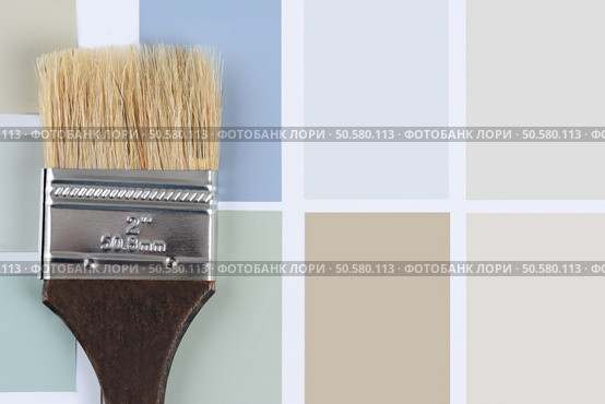 Overhead shot of  a paint brush with a brown handle laying on a sheet of color samples. Horizontal format with copy space. Стоковое фото, агентство Ingram Publishing / Фотобанк Лори