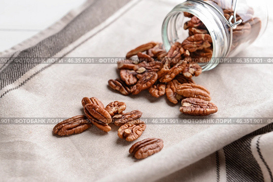 Overturned jar with pecan nuts on table. Стоковое фото, фотограф Pixel_shot / Фотобанк Лори