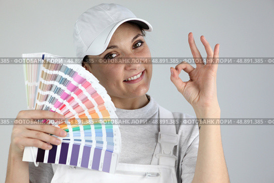 Painter giving the a-ok sign and holding a palette of colour samples. Стоковое фото, агентство Ingram Publishing / Фотобанк Лори