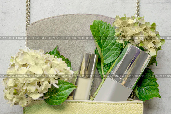 Pale yellow handbag with cosmetic bottle, lipgloss and hydrangea flowers on white wooden background. Feminine lifestyle concept. Top view. Стоковое фото, агентство Ingram Publishing / Фотобанк Лори