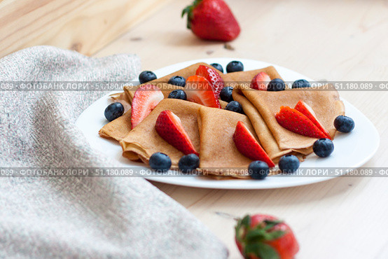 Pancakes with blueberries and strawberries on the table. Traditional food for Maslenitsa. Стоковое фото, фотограф Алина Лебедь / Фотобанк Лори