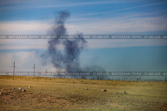 Panorama view on steppe and explosion. Coal extraction quarry in Kazakhstan. Black smoke on blue sky background. Стоковое фото, фотограф Alexey Rezvykh / Фотобанк Лори