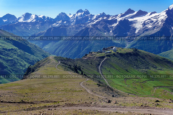 Panoramic mountain landscape with green highland valley, observatory in the distance and mountain peaks in the background. Стоковое фото, фотограф Евгений Харитонов / Фотобанк Лори