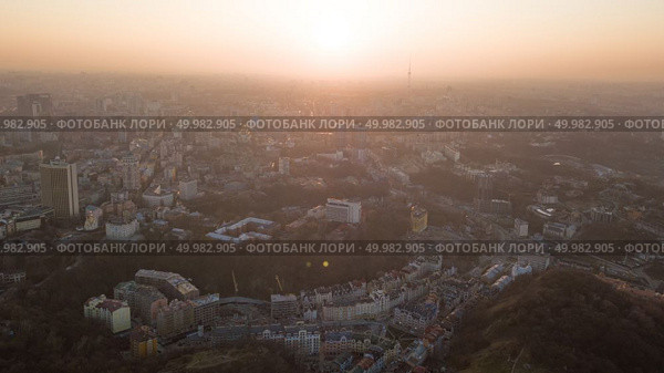 Panoramic view of a modern city center with an art college and a television tower, Vozdvizhenka and bald mountain under dramatic sunset sky in Kiev, Ukraine. Drone photo. Skyline bird eye aerial view of the city center with an art college and a television tower under dramatic sunset sky in Kiev, Ukraine. Стоковое фото, агентство Ingram Publishing / Фотобанк Лори
