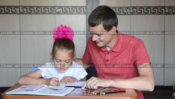Папа показывает дочке первокласснице, какие задания ей надо выполнять. Стоковое видео, видеограф Иванов Алексей / Фотобанк Лори