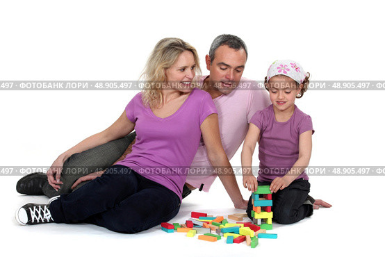 Parents watching their daughter play with blocks. Стоковое фото, агентство Ingram Publishing / Фотобанк Лори