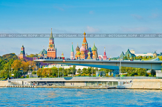 "Парящий мост" парка "Зарядье" на фоне Спасской башни Московского Кремля и Храма Василия Блаженного. Солнечный осенний день. Москва. Редакционное фото, фотограф E. O. / Фотобанк Лори