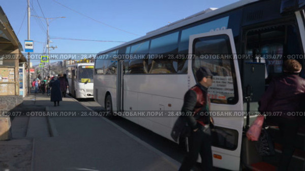 Пассажиры садятся в белый междугородний маршрутный автобус (2018 год). Редакционное видео, видеограф А. А. Пирагис / Фотобанк Лори