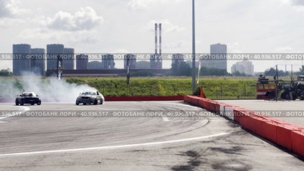 Passing a turn in a drift drift by cars. Races at the Moscow Grand Prix Drift at the motorsport stadium in Kuryanovo. Russia. Moscow. 30.07.2023. Стоковое видео, видеограф Ярославский Максим / Фотобанк Лори