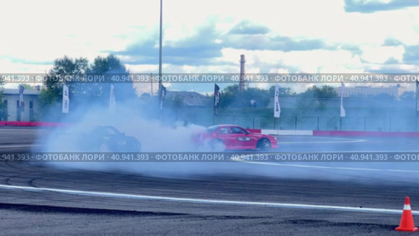 Passing a turn in a drift drift by cars. Races at the Moscow Grand Prix Drift at the motorsport stadium in Kuryanovo. Russia. Moscow. 30.07.2023. Стоковое видео, видеограф Ярославский Максим / Фотобанк Лори