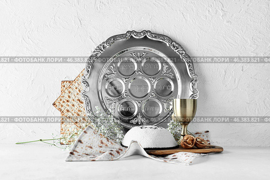Passover Seder plate with cup of wine, kippah and matza on white background. Стоковое фото, фотограф Pixel_shot / Фотобанк Лори