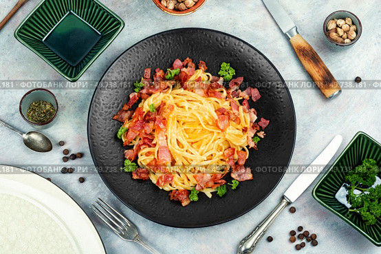 Pasta with roasted bacon served on a black plate, pasta carbonara. Italian pasta dish. Top view.. Italian classic pasta carbonara. Стоковое фото, агентство Ingram Publishing / Фотобанк Лори