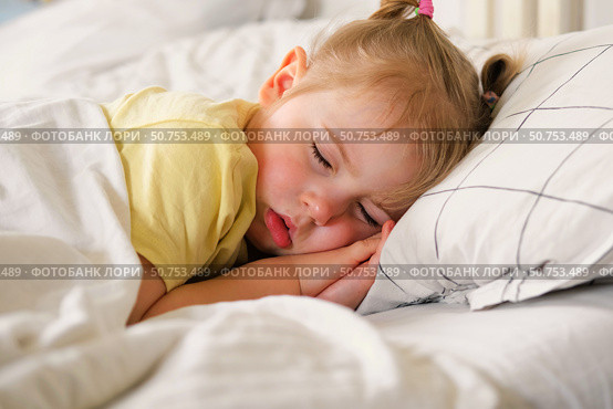 Peaceful adorable baby sleeping on a bed at home. Slumbering little child. Two years old girl sleeps peaceful at domestic room interior background. Serene dream. Cute face close up. Deep kid slumber. Стоковое фото, фотограф Марина Демидюк / Фотобанк Лори