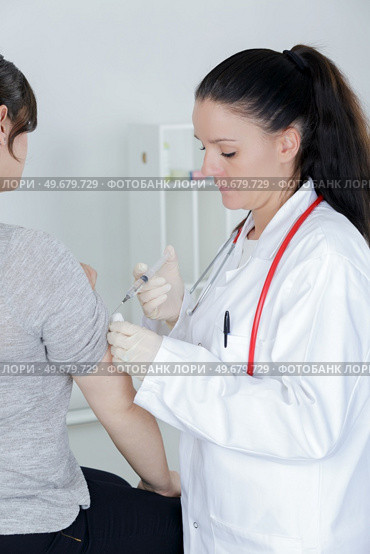 pediatrician giving an injection in arm. Стоковое фото, агентство Ingram Publishing / Фотобанк Лори