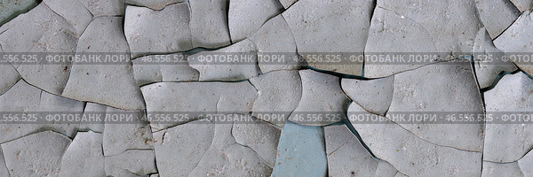 Peeling paint on the wall. Panorama of a concrete wall with old cracked flaking paint. Weathered rough painted surface with patterns of cracks and peeling. Wide panoramic grungy texture for background. Стоковое фото, фотограф Андрей Степанов / Фотобанк Лори