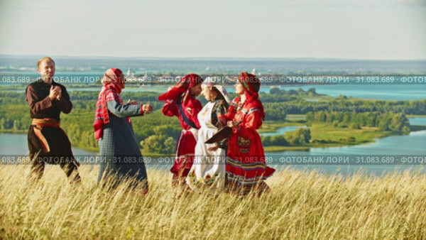 People in traditional russian clothes dancing on the field by the music from balalaika. Стоковое видео, видеограф Константин Шишкин / Фотобанк Лори