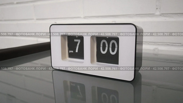 Перекидной циферблат часов будильника. Монтаж двух планов. Flip clock mechanism. 7:00 PM. Flip clock watch face. White brick wall in the background. Slow motion 240 fps. Стоковое видео, видеограф EStarodubov / Фотобанк Лори