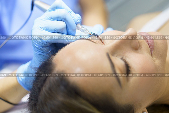 Permanent make-up for eyelashes of beautiful woman in a beauty salon. Close-up of beautician doing tattooing eyelashes. Micropigmentation treatment.. Permanent make-up for eyelashes of beautiful woman in a beauty salon. Micropigmentation treatment. Стоковое фото, агентство Ingram Publishing / Фотобанк Лори