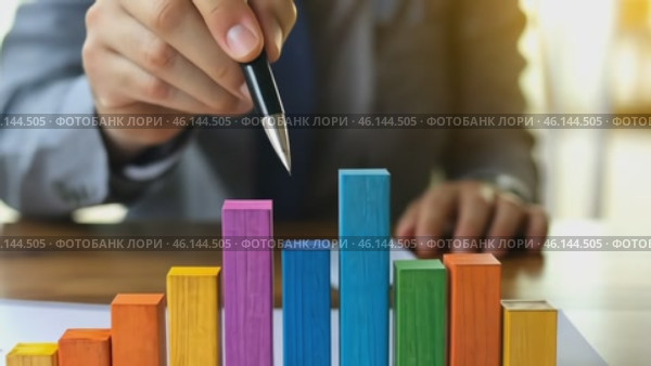 Person Holding a Pen Pointing Colorful Financial Charts, Analysis, Business Activities. Professional is Analyzing a Bar Graph, Data Trends, Report. Businessman Analyzing Document. Growth. Investment. Стоковое AI-видео, аниматор Марина Демидюк / Фотобанк Лори