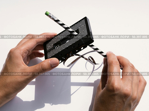 person repairing black cassette tape with pencil. Стоковое фото, агентство Ingram Publishing / Фотобанк Лори