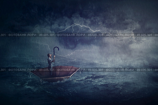Person sailing alone the ocean on an umbrella boat, looking for shore. Surreal scene with a storm over the sea. Fantastic adventure concept. Business despair metaphor, conquering and facing adversity. Стоковое фото, агентство Ingram Publishing / Фотобанк Лори