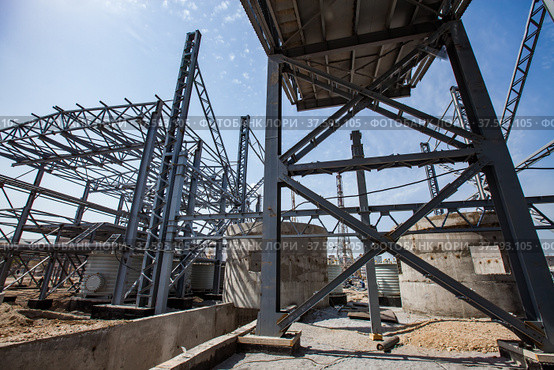 Phosphate fertilizers plant. New industrial building construction. Assembling steel structure. Concrete and metal elements on blue sky with light clouds. Стоковое фото, фотограф Alexey Rezvykh / Фотобанк Лори