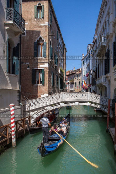 Picturesque view of Gondola on lateral narrow Canal, Venice, Italy. Classical picture of venetian canals with gondola across canal.. Venice canal scene in Italy. Стоковое фото, агентство Ingram Publishing / Фотобанк Лори