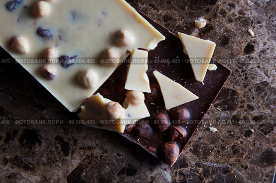 pieces of dark and white chocolate isolated on a dark marble background. pieces of dark and white chocolate. Стоковое фото, агентство Ingram Publishing / Фотобанк Лори