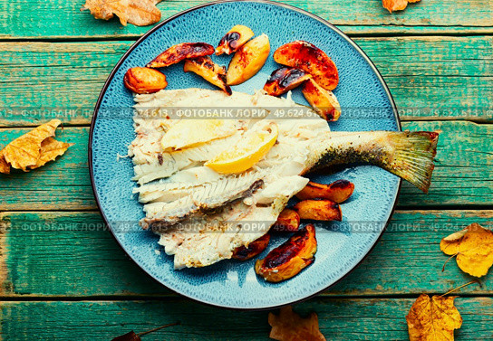 Pike perch baked with autumn fruits on old wooden table. Baked dietary fish with quince. Стоковое фото, агентство Ingram Publishing / Фотобанк Лори