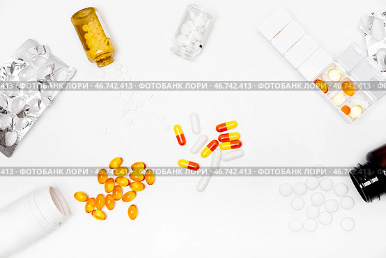 Pillbox by days of the week with fish oil and various pills, capsules and jars scattered on a white background, top view. Стоковое фото, фотограф Кашапова Эльвира / Фотобанк Лори