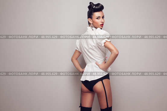 Pin up styling model posing in stocking, high shorts and white shirt. Updo. Стоковое фото, агентство Ingram Publishing / Фотобанк Лори