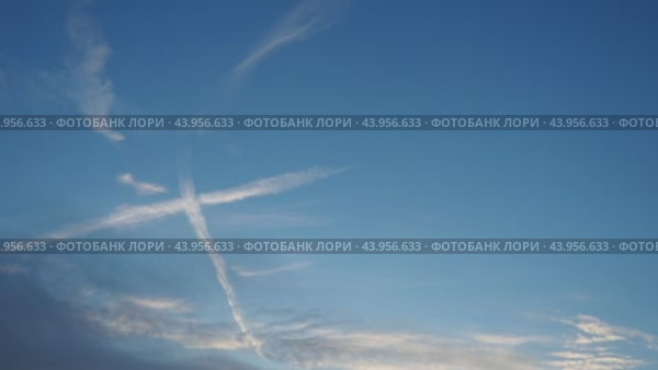 Plane leaves condensation trail. Chemtrail conspiracy theory. Long-lasting condensation trails left in sky by high-flying aircraft are actually chemtrails consisting of chemical or biological agents. Стоковое видео, видеограф Юлия Петровская / Фотобанк Лори