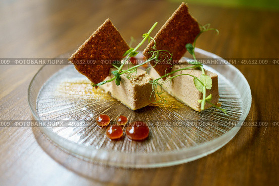 Plate of foie micuit with crispy croutons and drops of marmalade on a wooden table in a fine dining restaurant.. Plate of foie micuit with crispy croutons and drops of marmalade. Стоковое фото, агентство Ingram Publishing / Фотобанк Лори