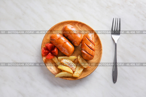 Plate with tasty grilled sausages and potatoes on light background. Стоковое фото, фотограф Pixel_shot / Фотобанк Лори