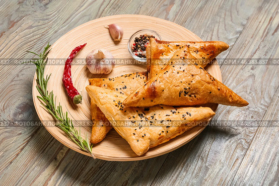 Plate with tasty Uzbek samsa and spices on wooden background. Стоковое фото, фотограф Pixel_shot / Фотобанк Лори