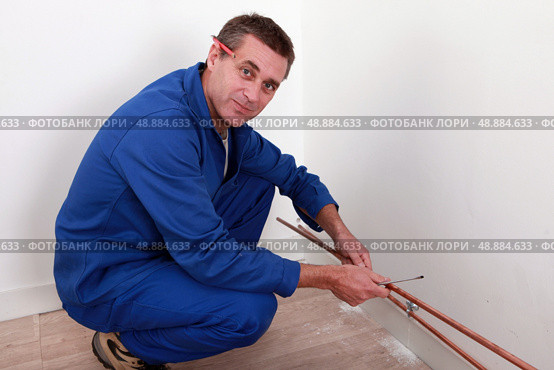 Plumber fixing copper piping. Стоковое фото, агентство Ingram Publishing / Фотобанк Лори