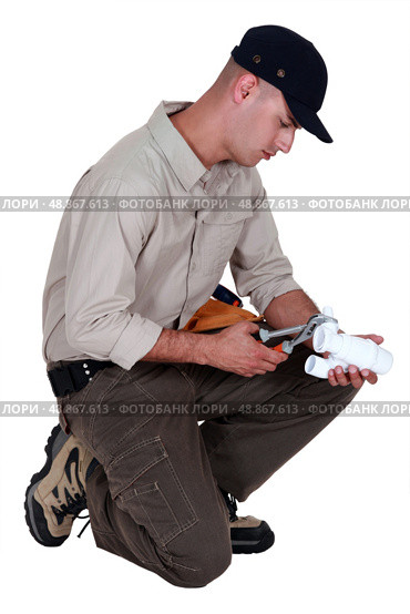Plumber using pliers to fasten two parts together. Стоковое фото, агентство Ingram Publishing / Фотобанк Лори